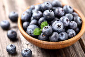 Ripe blueberry in a wooden plate